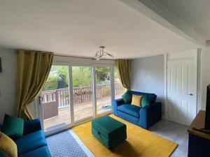 a living room with blue furniture and a large window at Betty’s Hideaway in Caernarfon