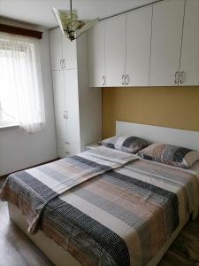 a bedroom with two beds and white cabinets and a window at Bolf in Novigrad Istria