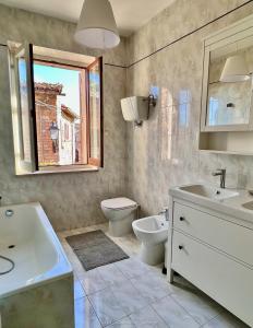 a bathroom with a sink and a toilet and a window at A Passo Lento nel Castello di Collepino - Spello in Spello +85 photos
