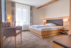 a bedroom with a bed and a desk and a chair at Gasthaus Blume in Willstätt