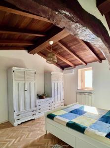 una camera con letto e soffitto in legno di A Passo Lento nel Castello di Collepino a Spello