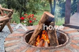 eine Feuerstelle aus einem Baumstumpf in der Unterkunft Casa com área de lazer e vista para as montanhas in Aguas Mornas