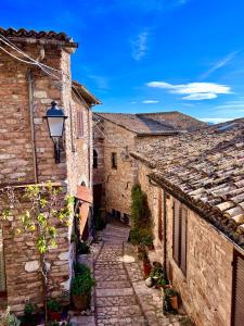 un vicolo in una città italiana con edifici in pietra di A Passo Lento nel Castello di Collepino a Spello