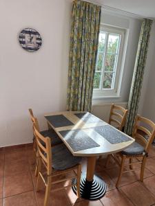 une table à manger avec des chaises et une fenêtre dans l'établissement Auszeit-mit-Kind-und-Hund, à Sagard