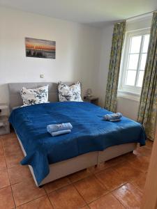 - une chambre avec un lit bleu et 2 serviettes dans l'établissement Auszeit-mit-Kind-und-Hund, à Sagard