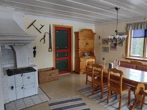 eine Küche mit einem Tisch, Stühlen und einer roten Tür in der Unterkunft Swedish Paradise Garden & Lake Retreat 