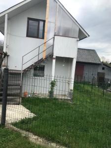 une maison blanche avec une clôture devant elle dans l'établissement Casa de vacanta Balan, à Prundul Bîrgăului
