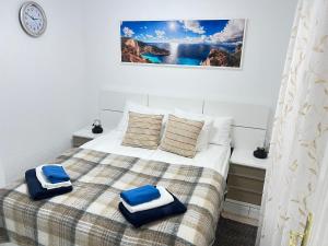 Un dormitorio con una cama con toallas azules. en Edificio Gloria en Los Cristianos
