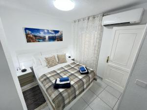 małą sypialnię z łóżkiem i drzwiami w obiekcie Edificio Gloria w mieście Los Cristianos