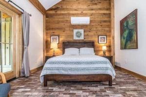 1 dormitorio con 1 cama y pared de madera en The Stables at Springhouse farm, en Lexington