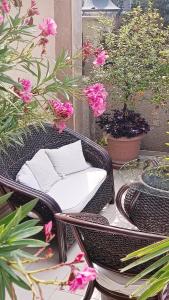 una sedia di vimini con un tavolo e alcuni fiori di Villa Rosi a Sozopol