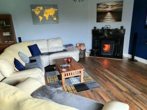 a living room with a couch and a table and a fireplace at castle Road House in Castletownbere +24 photos