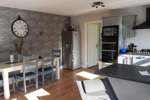 uma cozinha com uma mesa e um relógio na parede em castle Road House em Castletownbere