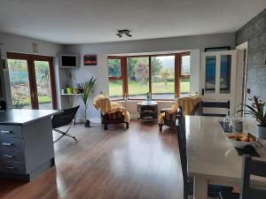 uma cozinha e sala de estar com mesa e cadeiras em castle Road House em Castletownbere