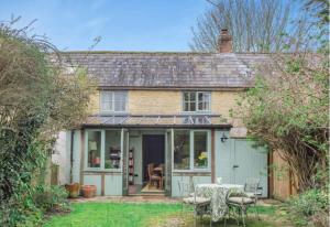 a house with a table and chairs in the yard at Little Cottage Shipton in Shipton under Wychwood