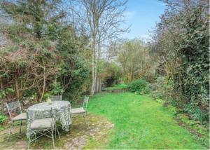 a table and chairs in a yard with trees at Little Cottage Shipton in Shipton under Wychwood +4 photos