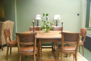 a dining room table and chairs with a vase of flowers on it at Little Cottage Shipton in Shipton under Wychwood