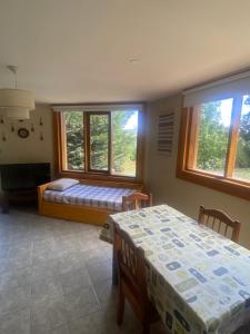 a bedroom with two beds and two windows at Casitas patagonicas in Villa La Angostura