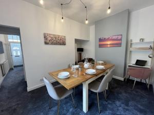 uma sala de jantar com uma mesa de madeira e cadeiras em Modernised 3-bedroom Blackburn townhouse sleeps 6 em Rishton