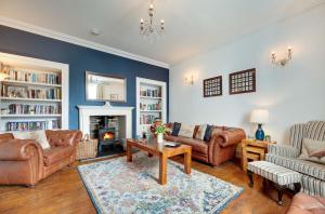 a living room with leather furniture and a fireplace at Salvin House Alston in Alston