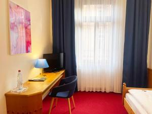 Cette chambre comprend un bureau avec un ordinateur et un lit. dans l'établissement Hotel Restaurant Krokodil, à Heidelberg