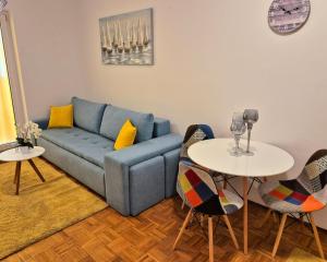 a living room with a blue couch and two tables at Apartman Lopar Selce in Selce