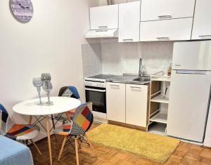 a kitchen with a table and a white refrigerator at Apartman Lopar Selce in Selce
