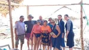 eine Gruppe von Leuten, die für ein Foto am Strand posieren in der Unterkunft Private Traditional Hut on the water with 2 rooms in Wichubualá