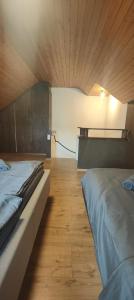 a bedroom with two beds and a wooden floor at Gästehaus Spring Herznach in Herznach