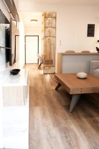 Una cocina y una sala de estar con una mesa de madera. en Aelia Luxury Properties - Executive Apartment, en Atenas