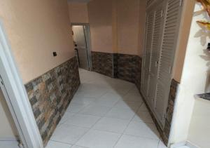 a hallway with doors and a tiled floor and a hallway with white tiles at Appartement médina Salé in Salé