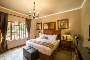 Un dormitorio con una cama grande y una lámpara de araña. en Tuareg Guest House en Midrand