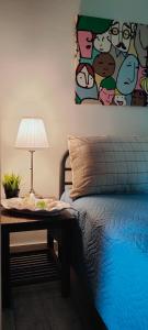 um quarto com uma cama com um candeeiro e uma pintura na parede em Cosy Garden Studio em Messini