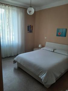 a bedroom with a large white bed and a window at Varazze Centro in Varazze