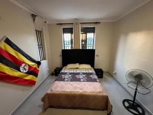 a bedroom with a bed in a room with a fan at Durlan metroplex in Kampala