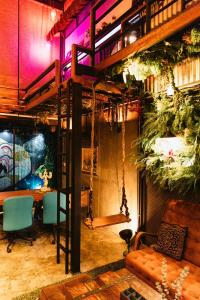 um quarto com uma cama alta, uma secretária e cadeiras em New York Loft & Japanese Magic by V4SKIN em Bangkok