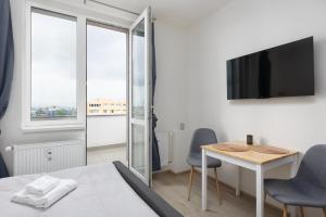 a bedroom with a bed and a table and a tv at Apartmán u metra s terasou in Prague