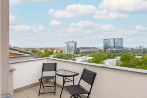 two chairs and a table on a balcony with a view at Apartmán u metra s terasou in Prague