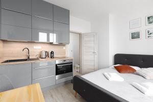 a bedroom with a bed and a sink and a kitchen at Apartmán u metra s terasou in Prague