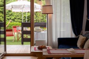 a living room with a view of a patio with an umbrella at Hotel Tyrol in Selva di Val Gardena