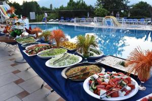 a buffet of food on a table in front of a pool at Ares Blue Hotel in Kemer