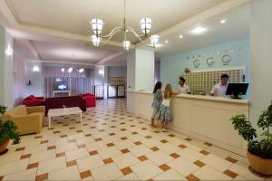 two people standing at a counter in a restaurant at Ares Blue Hotel in Kemer