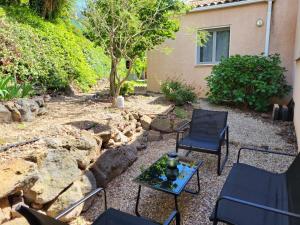 een patio met 2 stoelen en een tafel voor een huis bij Charmante dépendance au centre historique à Agde in Agde