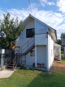 Una gran casa blanca con una escalera en el lateral. en Casa de vacanta Balan en Prundul Bîrgăului