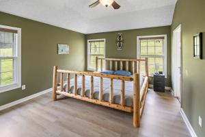 a bedroom with green walls and a wooden bunk bed at Private Farmhouse with Hot Tub in Dandridge +21 photos