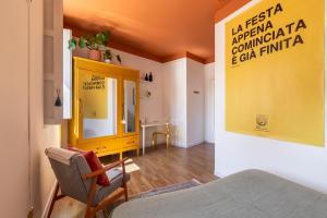 a room with a yellow cabinet and a chair at Homestay in Catania