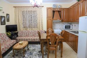 a kitchen and living room with a table and a couch at Rafael Apartment in Berat +5 photos