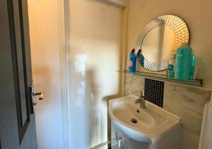 ein Bad mit einem Waschbecken und einem Spiegel in der Unterkunft Cosy 2 Bed Apt For Families With Free Parking in Liverpool