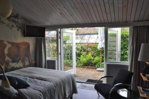 um quarto com uma cama e uma porta de vidro deslizante em B&B Slotstraat em Dreischor