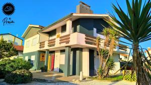 a building with a palm tree in front of it at A Praia, My Own Paradise- Estúdio in Figueira da Foz